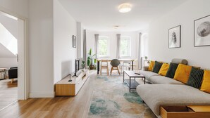 Un salon moderne comprenant un canapé, une table basse et un coin repas avec une table et des chaises.