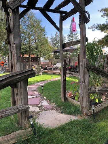 Large private fenced yard with guest patio, fire pit and surrounding gardens.