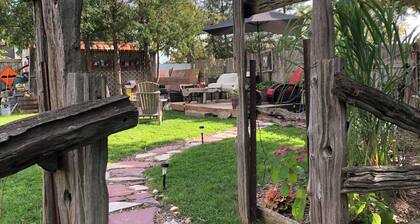 Large private fenced yard with guest patio, fire pit and surrounding gardens.