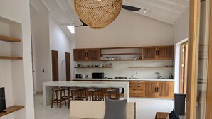 Una cocina moderna con armarios de madera, una isla central y taburetes de bar.