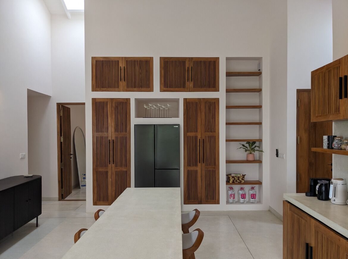 Een moderne keuken met houten kastjes, een centraal eiland en een koelkast.