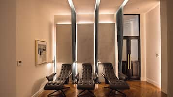 Relax in a comfortable seating area with three tufted armchairs and a polished floor.
