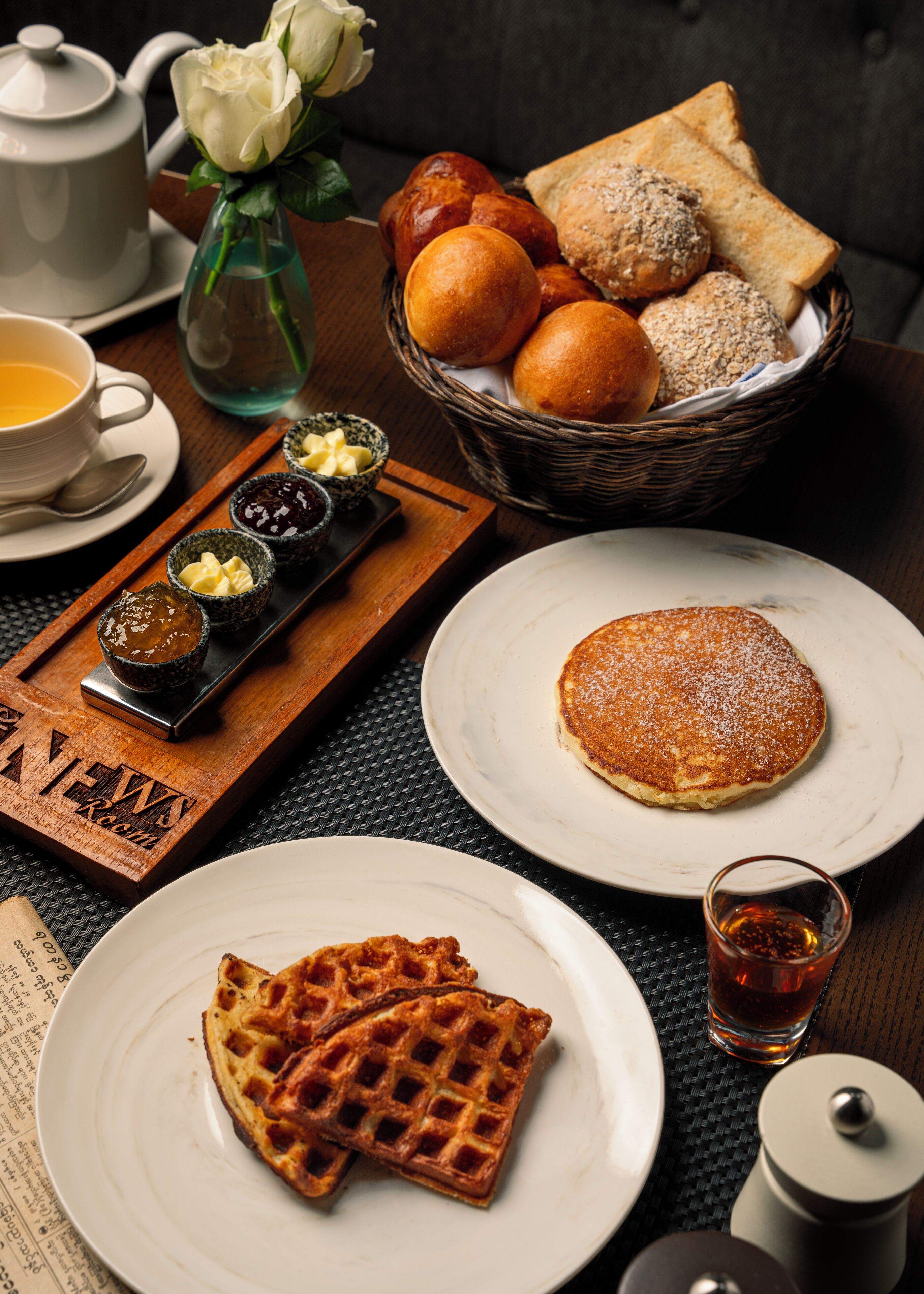 Desayuno con gofres, tortitas, tostadas y una variedad de mermeladas y cremas.