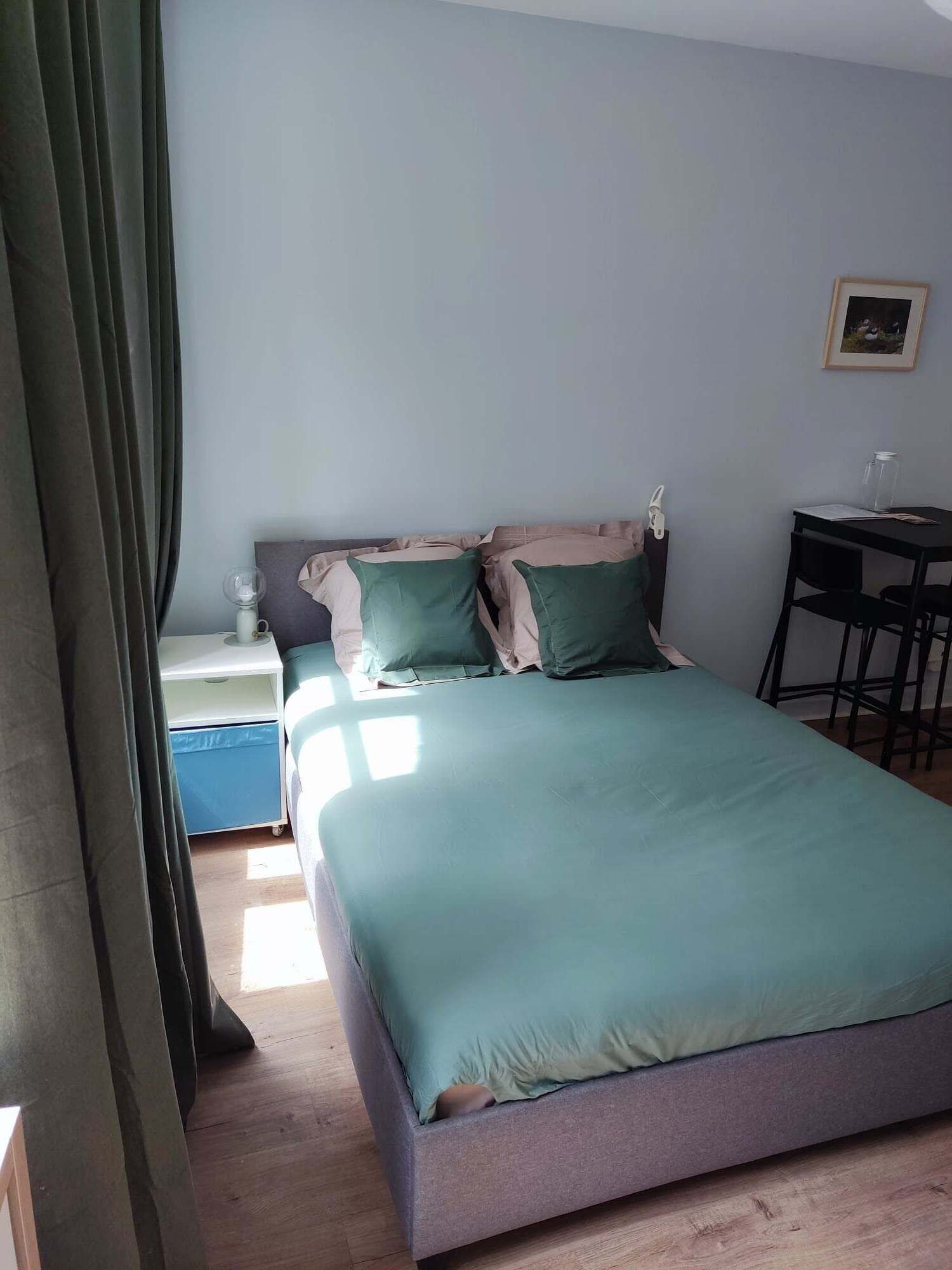 Ein Schlafzimmer mit einem Bett, einem Nachttisch, einem kleinen Tisch und einem Stuhl.