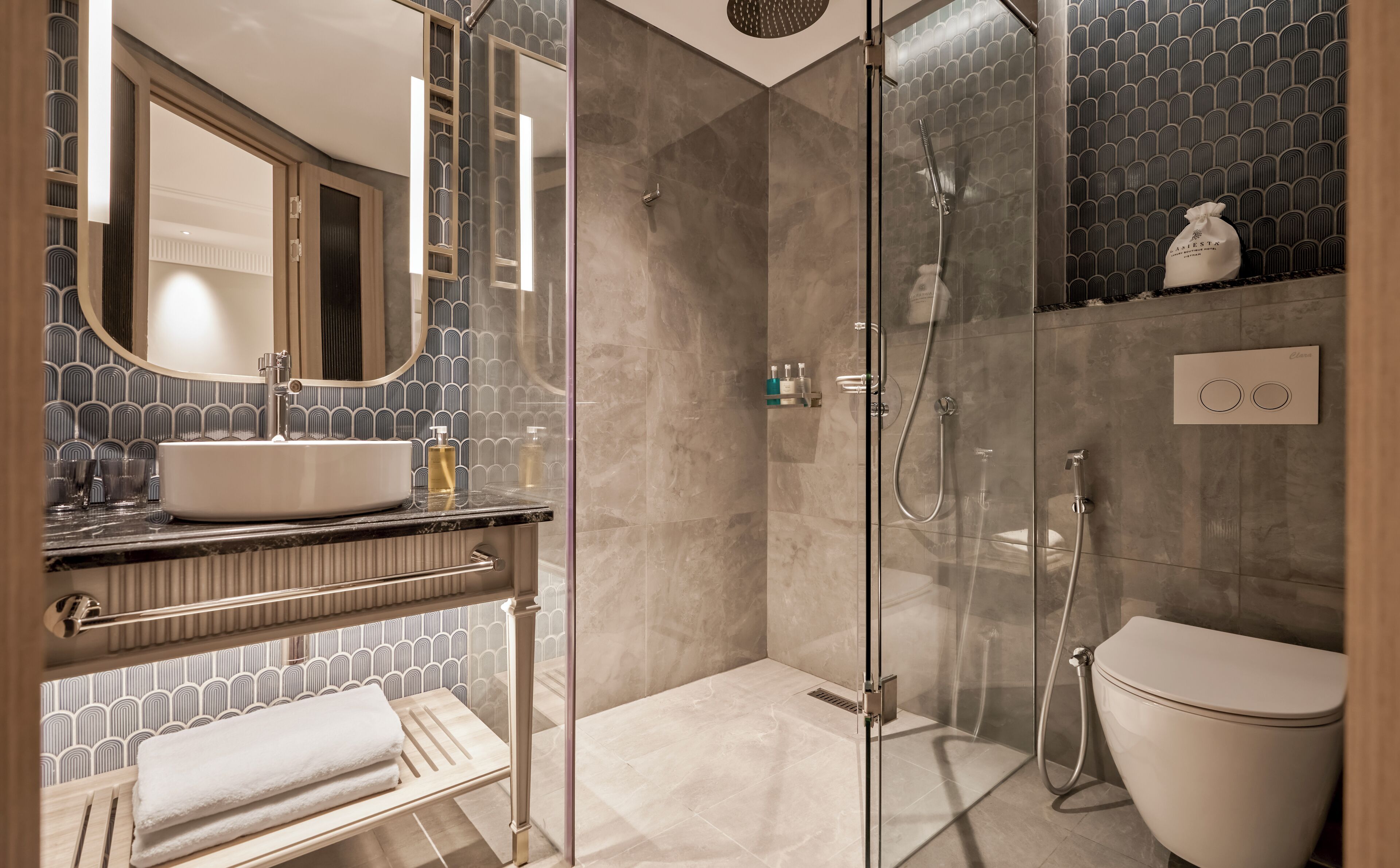 A modern bathroom with a glass-enclosed shower, a white sink, and a toilet.