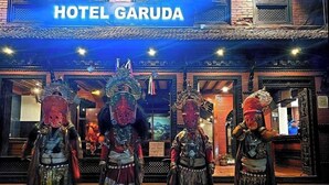 A hotel entrance with traditional attire figures and a sign reading "HOTEL GARUDA". - Hotel Garuda Bhaktapur (Bhaktapur)