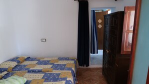 A bedroom with a bed, a wardrobe, and a door leading to another room. - Appartamento in Casa Paiesa, San Fernando Dista in 5 Minuti (Formentera Islas Baleares)