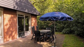 A patio with a table and chairs under a blue umbrella with 'Summio.parc's' branding.