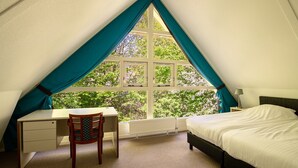 A bedroom with a bed, a desk, and a chair. There is a window with curtains. - Markegaerde Wellness 4 (Ruinen)