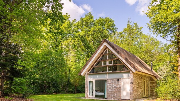 A small, single-story cabin with a sloped roof, large windows, and a door leading to a covered porch. - Markegaerde Wellness 4 (Ruinen)