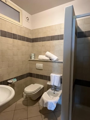 Et badeværelse med toilet, bidet og håndvask.