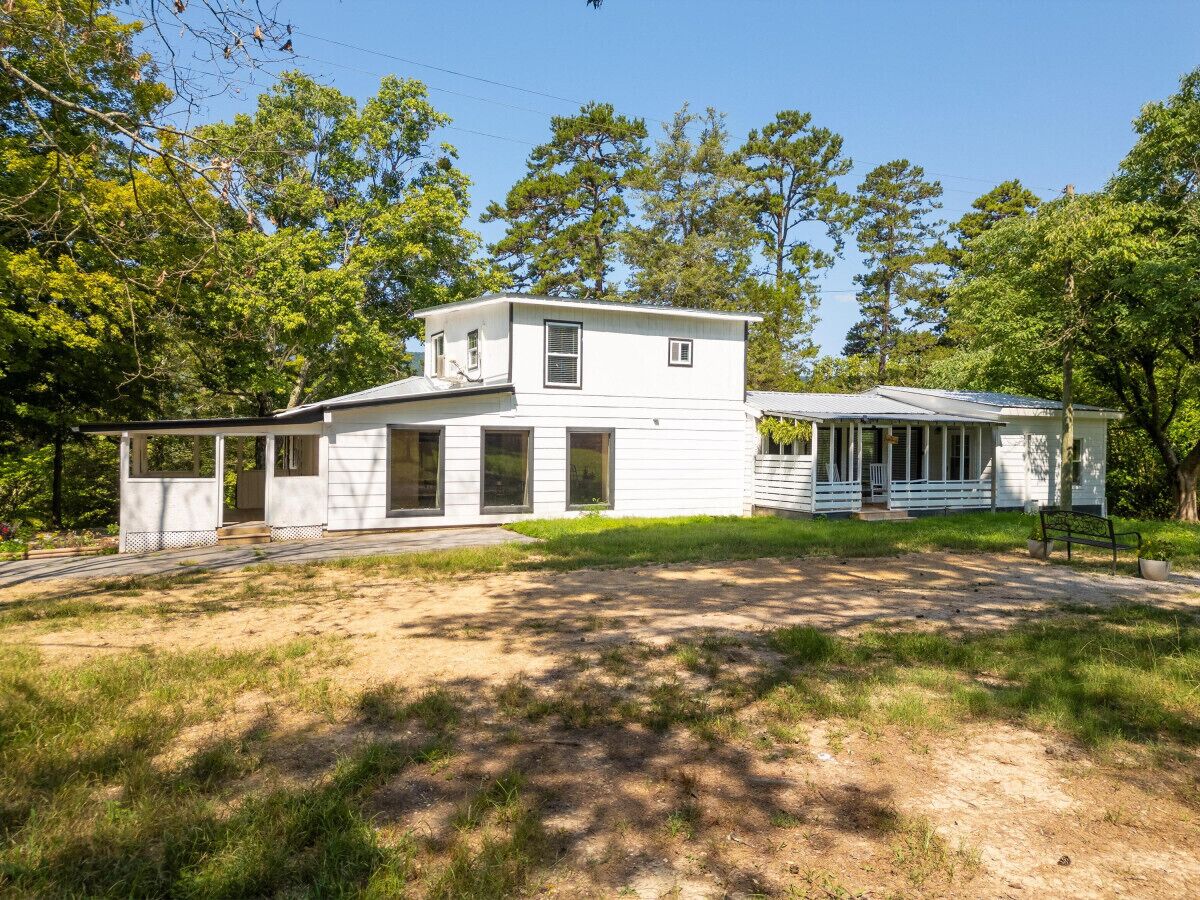 A two-story white house with a porch and a covered porch area.