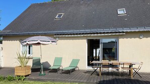 A house with a patio, a table, and two chairs. - Vacation home on enclosed land 800 metres from the beach and shops (Mesquer)