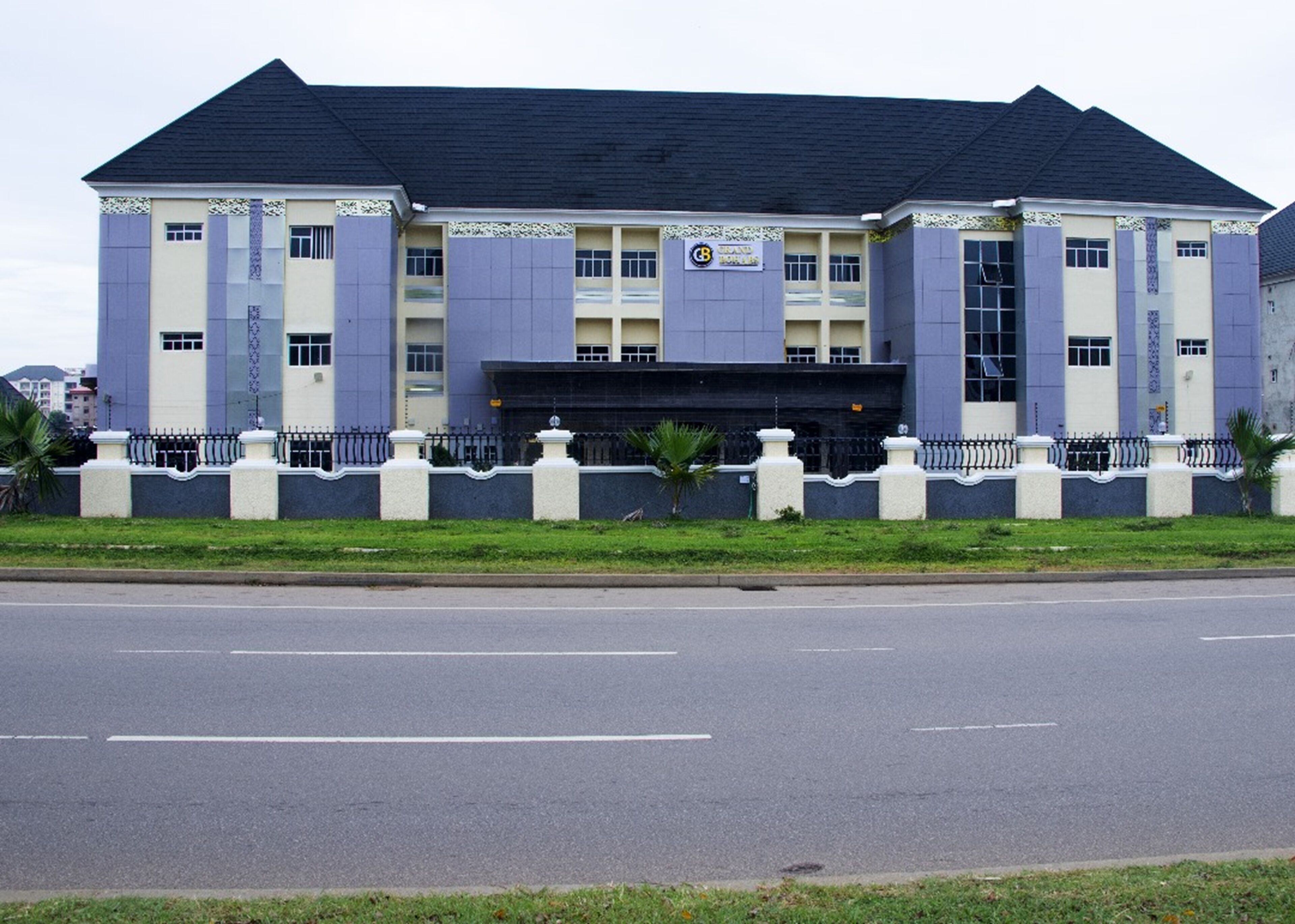 A large, modern building with a symmetrical facade, multiple windows, and a central entrance.