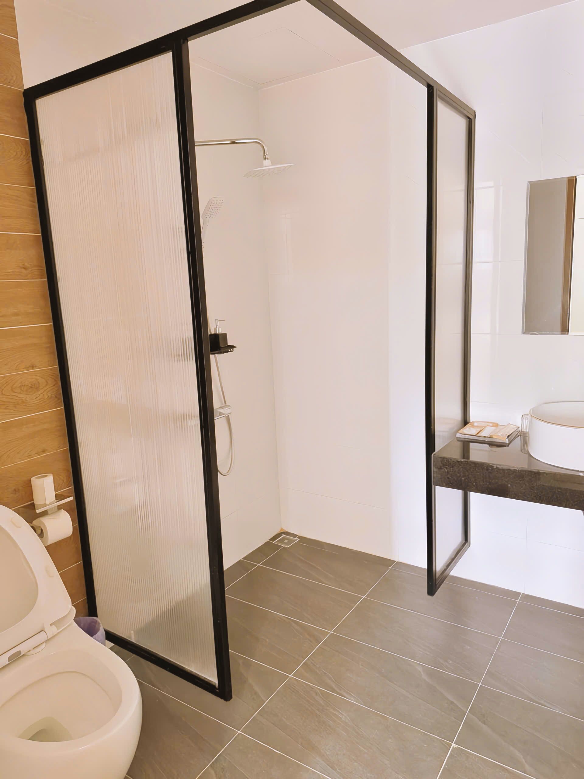 A bathroom with a shower, toilet, and sink.