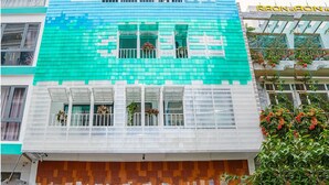 Un edificio de varios pisos con un diseño de fachada pixelado característico, que combina colores azul y naranja.