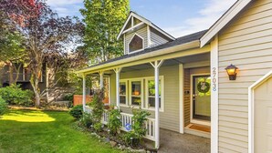 A single-story house with a porch, a garage, and a well-maintained lawn. - Bodur's Rustling Leaves - EV Charge, BBQ, Privacy (Renton)