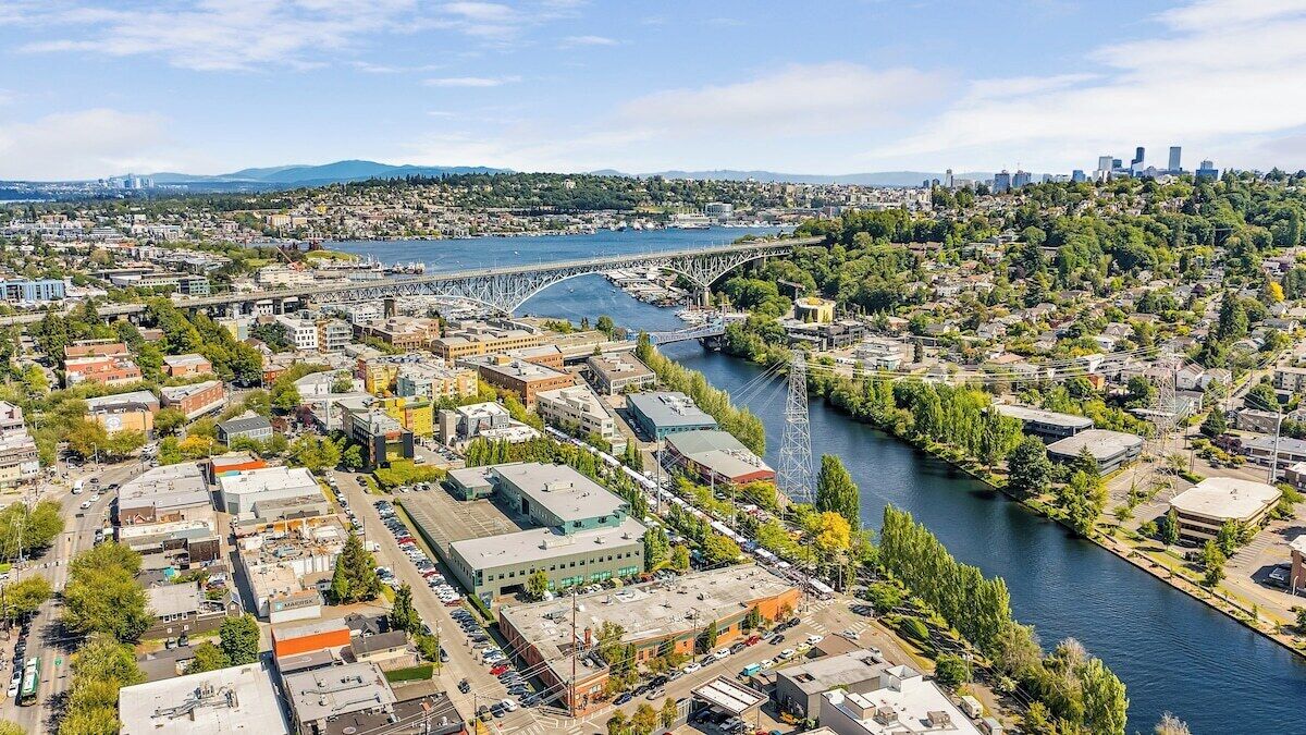 An aerial view of a city with a river, bridges, and a mix of residential and commercial buildings.