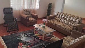 A living room with a sofa, two armchairs, a coffee table, and a patterned rug. - Beautiful One Bedroom with WiFi in Brumalia Mandeville, Manchester (Mandeville)
