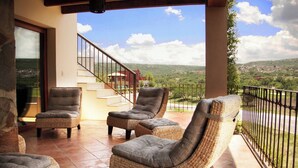 A covered outdoor seating area with wicker furniture and a view of a distant landscape. - Serene Oasis in San Miguel de Allende 6-bedroom Villa With Hot Tub (San Miguel de Allende)