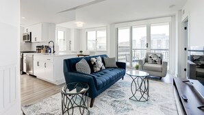 Een modern appartement met woonkamer, keuken en balkon.