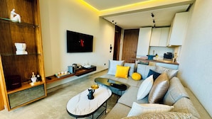 A modern living room with a sofa, coffee table, and a TV mounted on the wall. - Stay'Inn - Rafina Sunset (Casablanca)