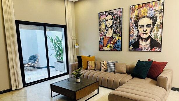 A modern living room with a sofa, coffee table, and artwork on the wall.
