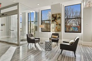 Enjoy a comfortable waiting area with a seating arrangement and floor-to-ceiling windows offering scenic views.