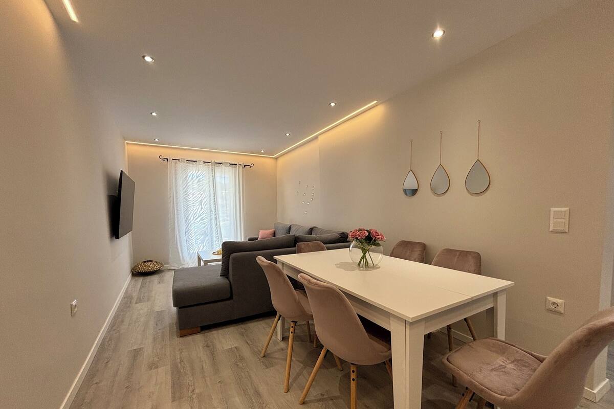 Ein modernes Wohnzimmer mit einer Couch, einem Esstisch und Stühlen.