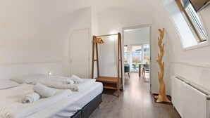 Une chambre à coucher avec un lit à baldaquin, une échelle en bois et une vue sur l’extérieur par une porte.