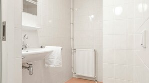 A bathroom with a white sink, a mirror, and a white towel hanging on the wall. - Comfortable bungalow for 6 persons (Midlaren)