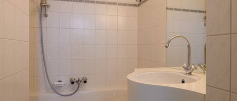 Une salle de bain avec une baignoire, un lavabo et une douche.