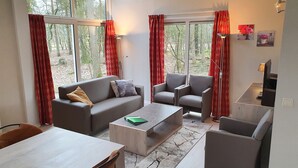 Una sala de estar moderna con un sofá gris, sillones y una mesa de centro.
