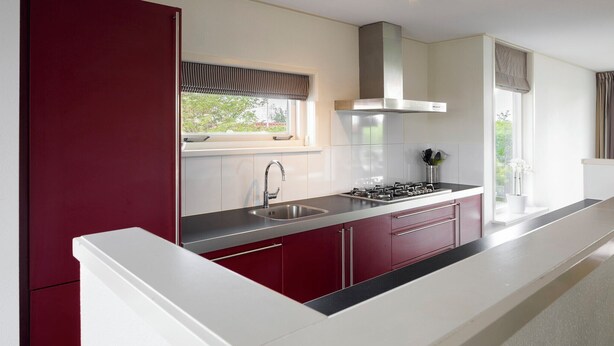 A modern kitchen with a stainless steel sink, a gas stove, and a range hood. - Zilvermeeuw Wellness Plus 6 (Noardburgum)