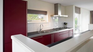 A modern kitchen with a stainless steel sink, a gas stove, and a range hood.