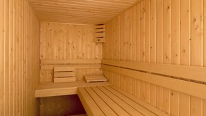 Un sauna en bois avec des bancs et une banquette.