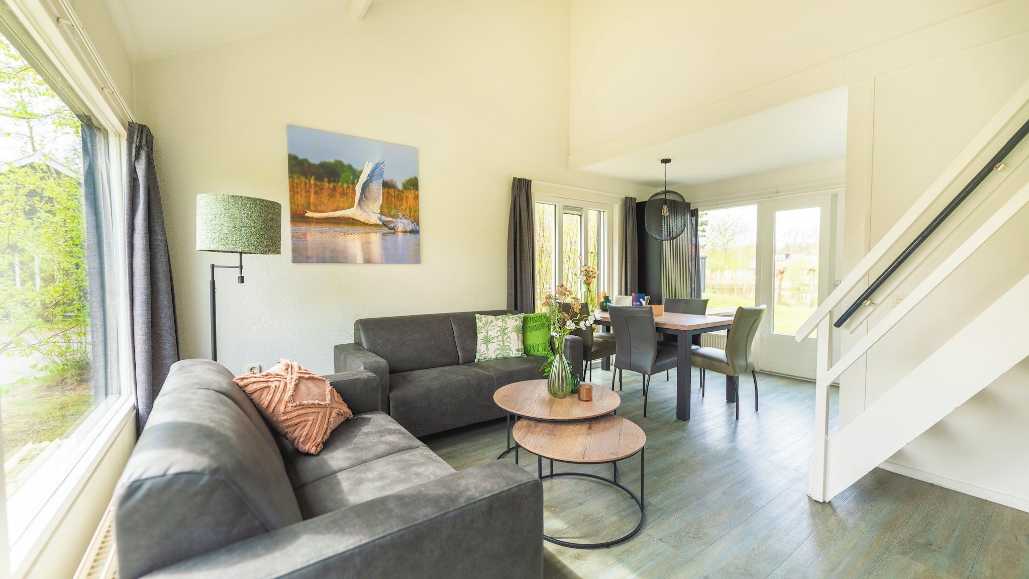 A modern living room with a sofa, coffee table, and dining area.
