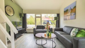 A modern living room with a grey sofa, a coffee table, and a TV on a stand.