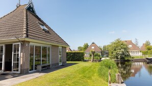 Un immeuble résidentiel doté d’un toit en pente, de grandes fenêtres et d’une façade en briques.