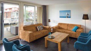 Ein modernes Wohnzimmer mit zwei Sofas, einem Couchtisch und blauen Sesseln.