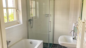 A modern bathroom with a glass-enclosed shower, a bathtub, and a sink. - Schoonhoven Wellness 6 (Hollandscheveld)