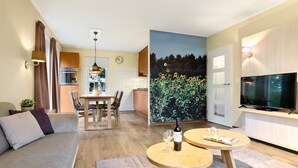 Un apartamento moderno con comedor, cocina, sala de estar y un televisor grande.