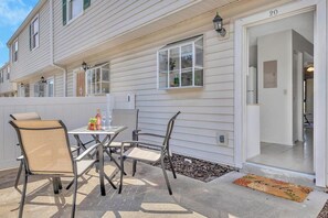 A residential building with a patio area featuring a table and chairs, a window with a view, and a door marked with the number 20. - Spacious Downtown Historic Springfield Condo  (Jacksonville)