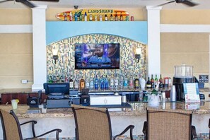 Zona de bar con una pantalla de televisión, varios botellones y un tablero de menú.