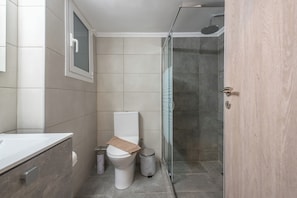 A modern bathroom with a toilet, bidet, and shower. - Stylish City Apartment by Cloudkeys  (Athens)