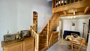 A wooden staircase leading to a loft bedroom with a bed and a desk. - T2 Mezzanine Villa - Air Conditioning - Veranda - Parking - Pool - 6 People (Fleury-Saint-Pierre-la-Mer)