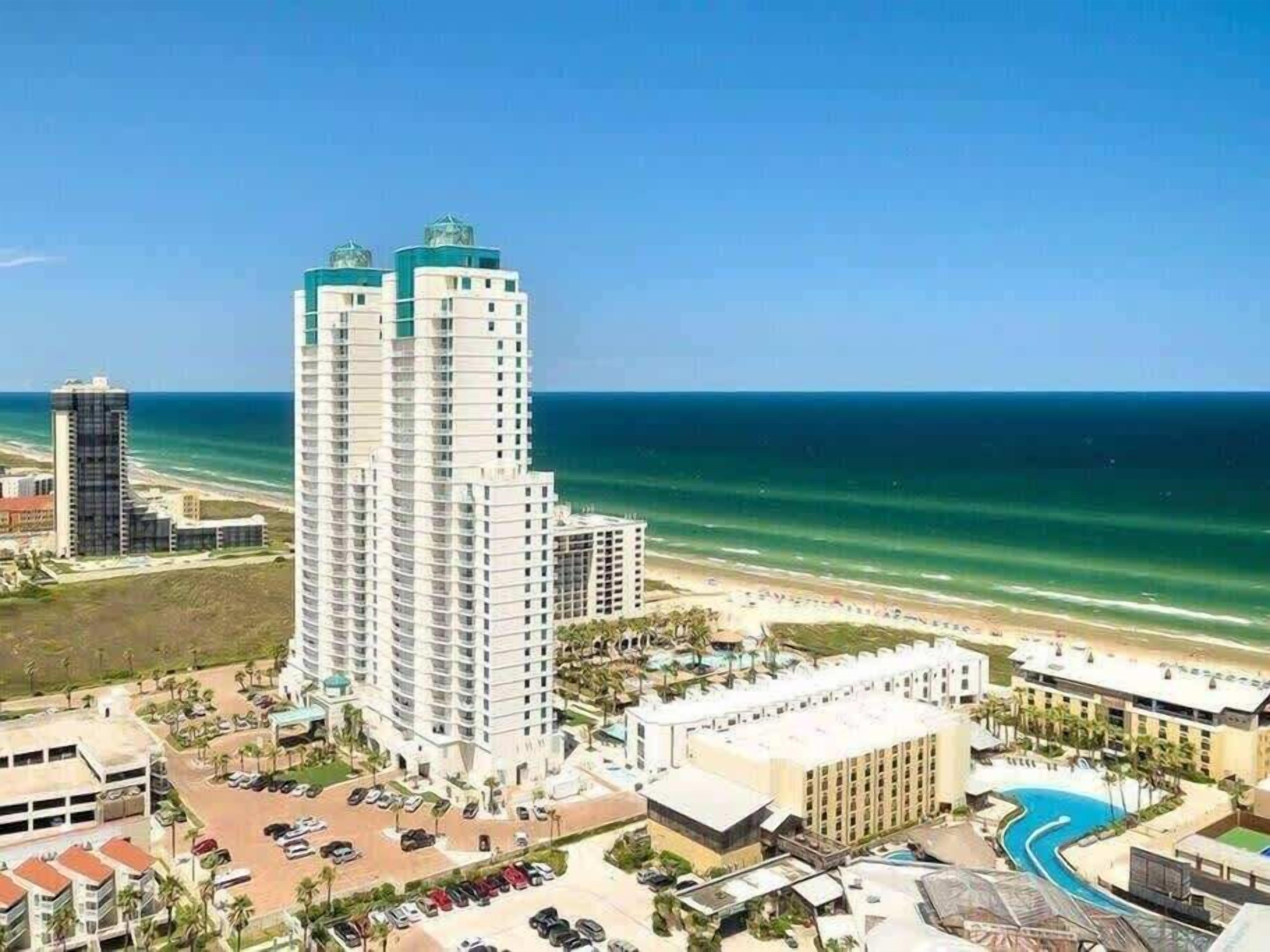 Un hôtel de grande hauteur avec piscine et vue sur la plage.