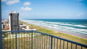 Un immeuble de grande hauteur offrant une vue sur l’océan et la plage.