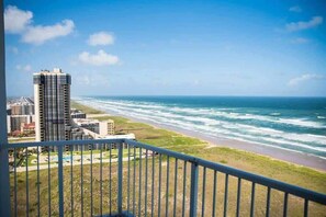 Un edificio alto con vistas al océano y a la playa.