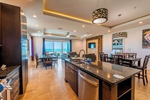 Una cocina moderna con una isla central, electrodomésticos integrados y un comedor con vistas.